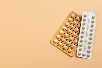 Blisters of contraceptive pills on beige background, top view. Space for text