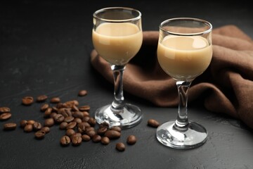 Coffee cream liqueur in glasses and beans on black table