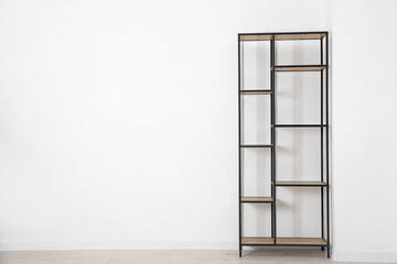 Empty shelving unit near white wall indoors, space for text