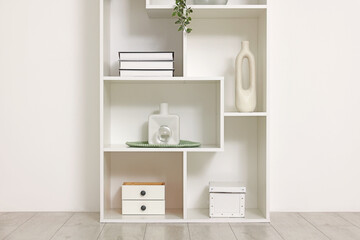 Shelving unit with decor near white wall indoors
