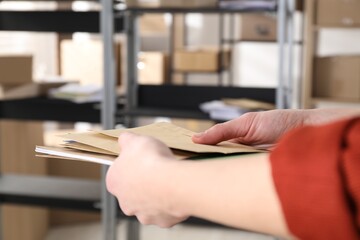 Woman with many different envelopes in post office, closeup. Space for text