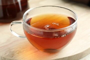 Aromatic tea in cup on light marble board, closeup