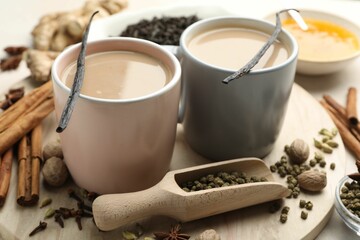 Aromatic Masala tea in cups, spices and honey on table, closeup