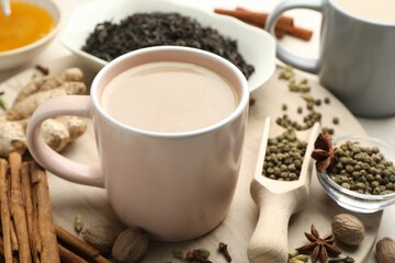 Aromatic Masala tea in cup, spices, dry leaves and honey on table, closeup