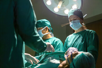 surgeon group operating surgery saving patient in operation. team doctor trying to help person using surgery procedure in er room. professional team using metal medical equipment saving sick patient