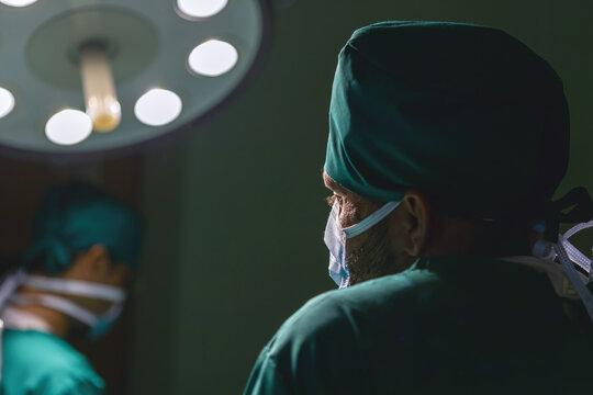 tired male caucasian doctor break operating. specialist surgical man exhausted working hard doing surgery rest in the back. male surgeon wearing uniform have break from working in emergency operation