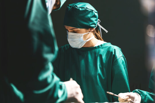 female caucasian doctor operating emergency room. specialist surgical woman determined doing surgery to help patient in operating room. female surgeon wearing uniform working in emergency operation