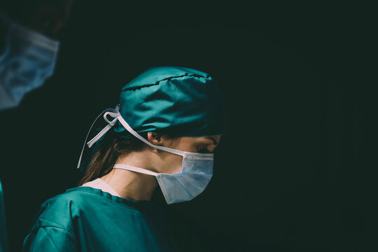 female caucasian doctor operating emergency room. specialist surgical woman determined doing surgery to help patient in operating room. female surgeon wearing uniform working in emergency operation