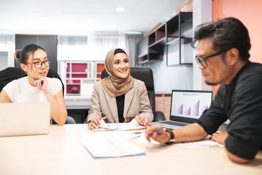 business muslim and asian woman and man have meeting. adult worker present showing benefit for company. international convention room with group of diversity people having a conversation in workplace
