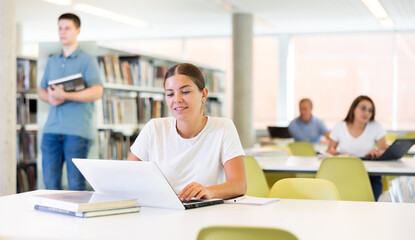 Smart female American student preparing for the exam in the school library