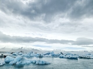 Icebergs floating in Jokulsarlon glacier lagoon in Iceland under cloudy sky
