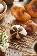 Easter egg with herbs attached to them with old cloth - preparation for dyeing with onion skins