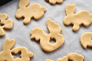 Linzer cookies in the shape of Easter hens and bunnies cut out from raw pastry dough