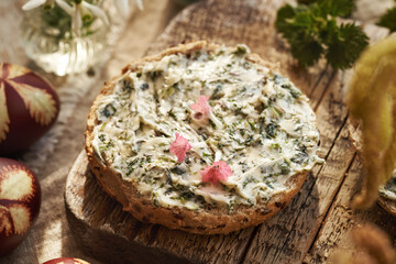 A slice of bun with nettle butter with wild edible lungwort flowers