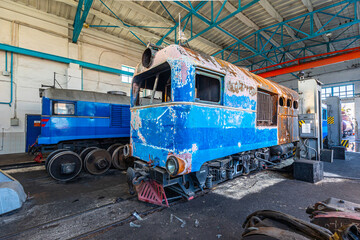 Old fault soviet diesel locomotive is in the hangar. Repair railway shop