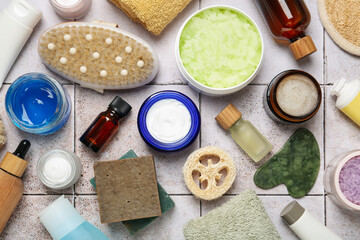 Different body care products on light tiled table, flat lay