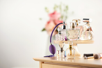 Different luxury perfumes on wooden dressing table indoors, space for text