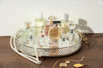 Different luxury perfumes and accessories on wooden table