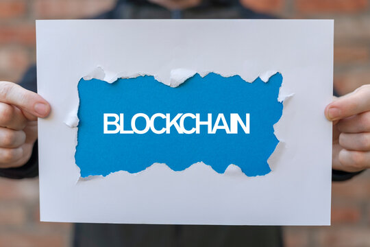Blockchain technology and network concept. Person holding paper sheets banner with text: BLOCKCHAIN.