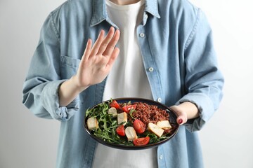 Woman refusing to eat meal on white background, closeup. Food allergy concept