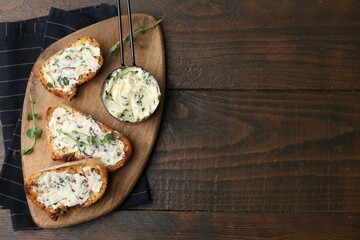 Tasty bread with garlic, herbs and oil on wooden table, top view. Space for text