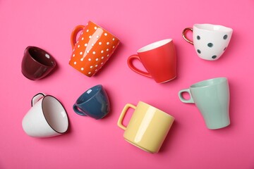 Many colorful cups on pink background, flat lay