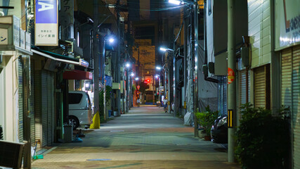 Osaka, Japan - Sep 22 2024, panoramic view of a narrow street in a residential area illuminated by pale lanterns, at night, without people, Osaka, Japan
