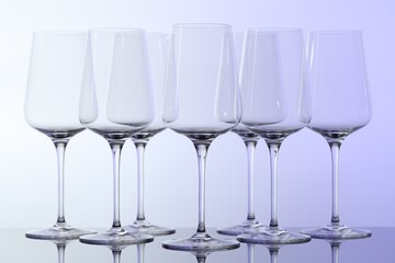 Many clean glass on mirror surface against light background