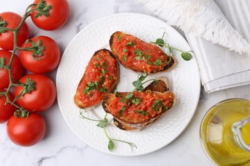 Tasty bread with tomatoes, parsley and oil on white marble table, flat lay