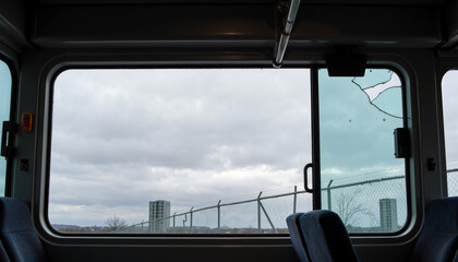 Interior view of empty bus with cloudy sky through large window – junkyard concept
