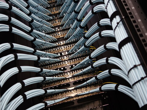 Intricate Array of Fiber Optic Cables in Server Rack Setup