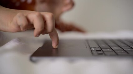Closeup of finger typing on laptop keyboard in a cozy home environment