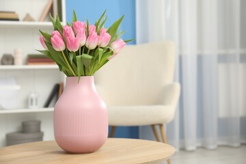 Bouquet of beautiful tulips in vase on wooden table indoors, space for text