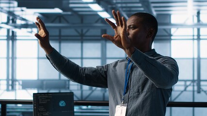 Computer scientist looking at holograms in data center, using artificial intelligence. African american admin interacting with augmented reality AI visualization in server hub, camera A