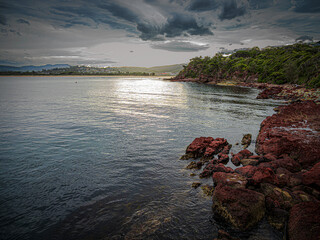 Red Rocks On Headland Lead To Town