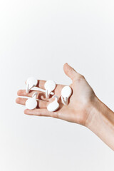 Hand holding set of five white plastic sponges on white background, close up in palm