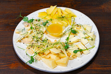 Gourmet cheese platter with honey and fresh fruits at a restaurant