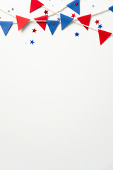 USA holiday vertical banner design. American flag color bunting garland with confetti stars on white background. Flat lay, top view