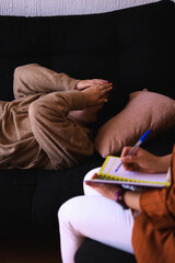 Woman psychologist attending to a female patient in her consulting room