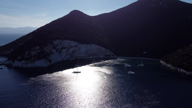 Aerial view of the sailing boats anchored off the shore of the island of Atokos, Greece at sunset