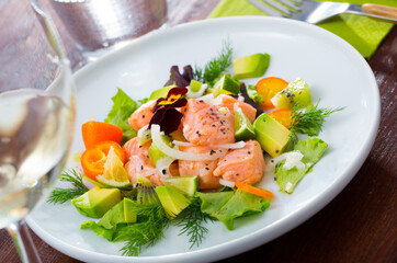 Delicious ceviche with salmon fillet, avocado, kumquat and greens