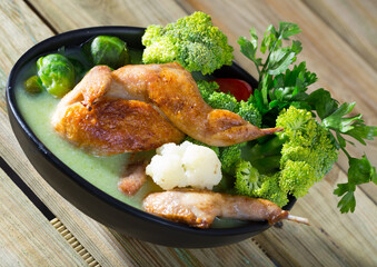 Vegetable broth with cauliflower, Brussels sprouts and broccoli served with fried quail meat, tomatoes and parsley