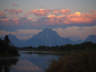 Expansive Wyoming landscape with rugged mountains, open plains, crystal lakes and dramatic skies, capturing the wild beauty of the American West.