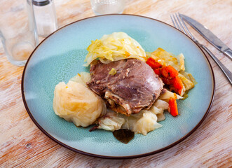 Image of baked pork cheeks with cabbage and carrot served on plate