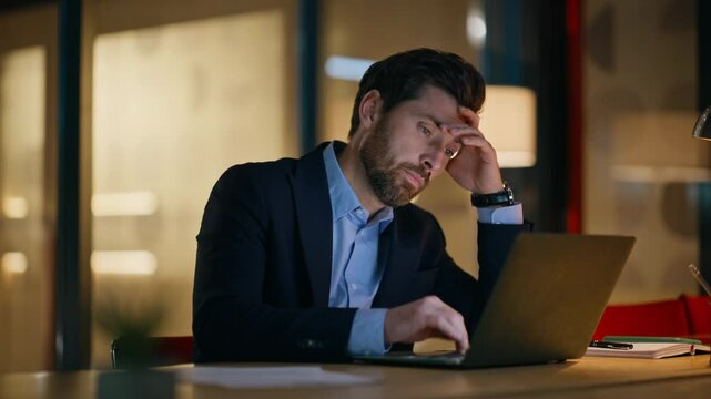 Overworked businessman typing laptop checking time at night office closeup.