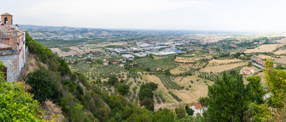 Panoramic view of countryside landscape with olive trees and rolling hills in Verucchio, Italy.