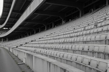 Deserted Stadium Bleachers: An Empty Row of Gray Seating at a Sports Arena Capturing the Desolate Atmosphere of Unused Spectator Space