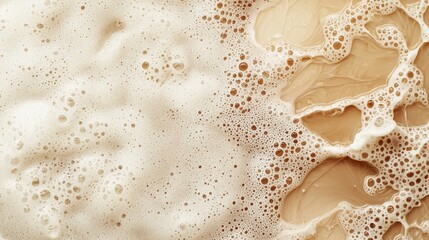 Translucent droplets of hydraulic fluid swirl creating creamy beige foam texture against a backdrop of darker liquid swirls