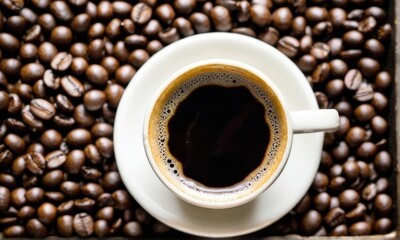 Fototapeta premium Overhead View of Coffee Cup on Coffee Beans