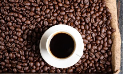 Fototapeta premium Overhead View of Black Coffee in White Cup on Coffee Beans